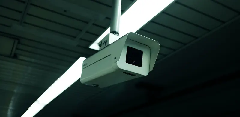 Security camera mounted under the roof of a building