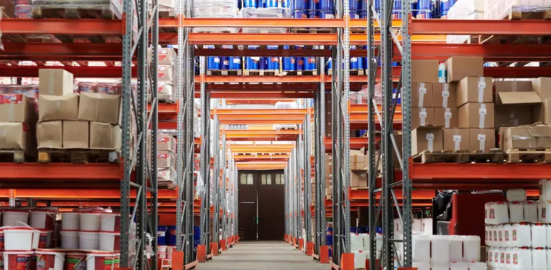 Warehouse aisle with tall pallet racking stocked with boxes and goods