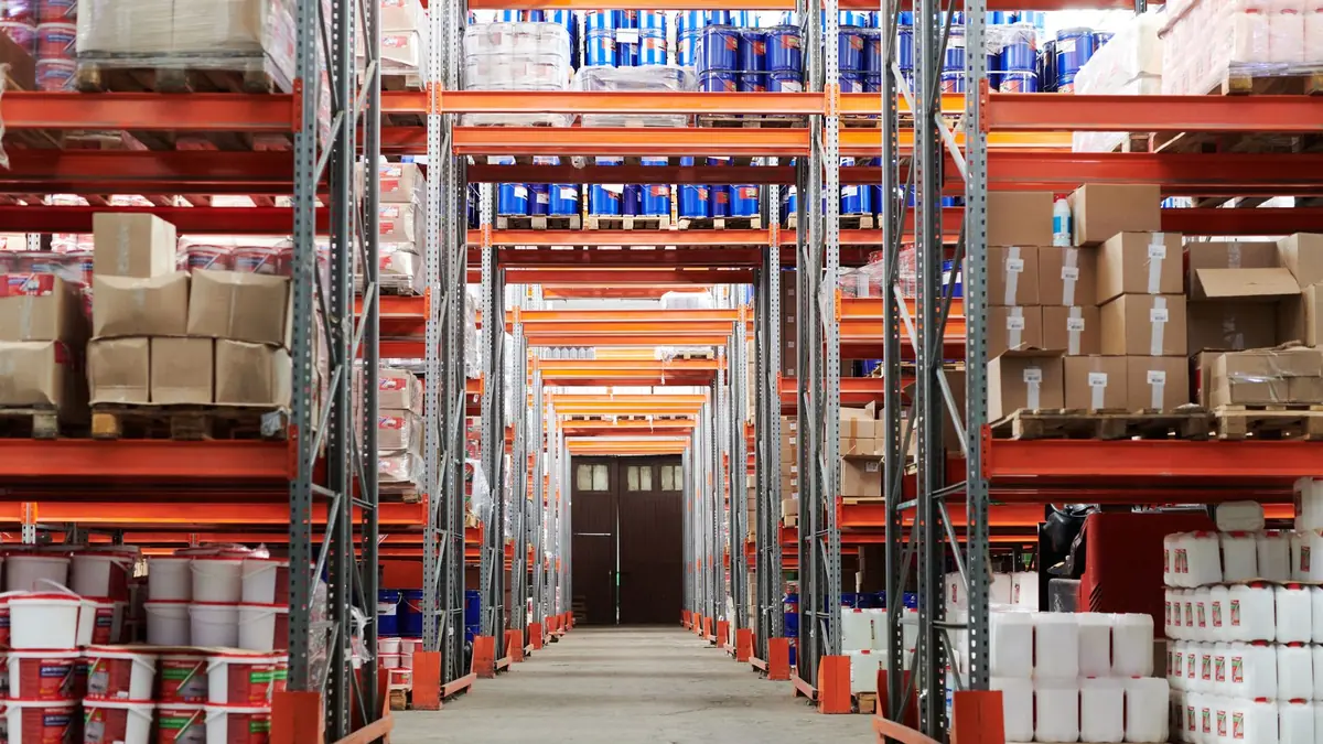 Warehouse aisle with tall pallet racking stocked with boxes and goods