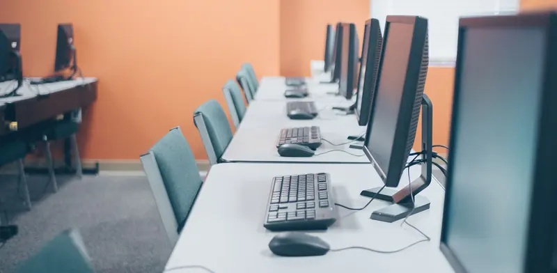 Rows of new workstations with monitors, keyboards and mice set up in an office