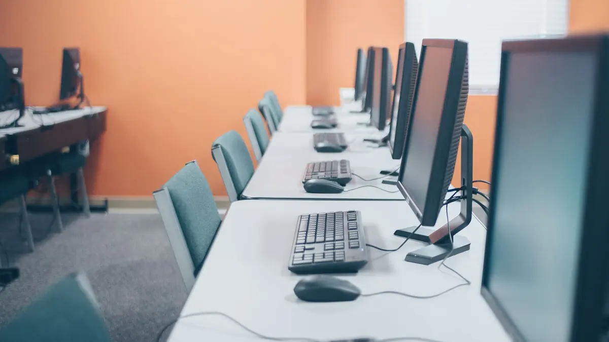 Rows of new workstations with monitors, keyboards and mice set up in an office