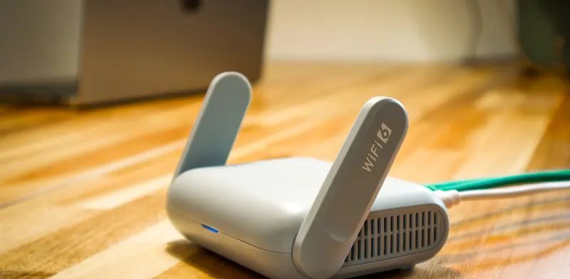 Wi-Fi router with an ethernet cable connected, on a desk at home