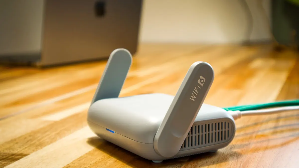 Wi-Fi router with an ethernet cable connected, on a desk at home